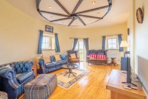Living room in the Witches Mill with curved stone walls Curved stone walls and furnishings following the circular shape of the Witches Mill interior.